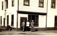 [Three men standing in front of a storefront in Golden, B.C.]