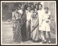 [Ajaib and Nirmal standing with an older woman and several young adults]