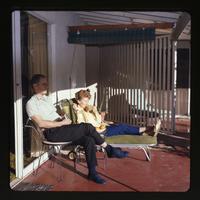 [Richard and Doris Chambers sitting on a porch in the sun]