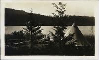 [Tent setup next to a lake or bay in an unknown location]