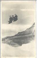 [Three people sitting on a snow-covered roof in Stewart, B.C.]