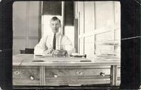 [Doukhobor man sitting at a desk in an unknown location]