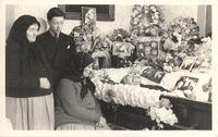 [Two Doukhobor women and a boy next to Peter Verigin's open casket in an unknown location]