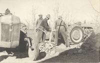 [Three Doukhobor men working on a tractor in an unknown location]