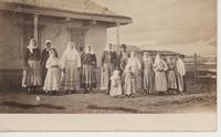 [Group portrait of several Doukhobors in front of a dwelling in an unknown location]