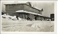 [Dog sled teams in front of a railway station in an unknown location]