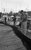 [Three men handling fishing nets on a dock]