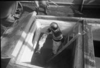 [Crew member cleaning out a fish storage area on a fishing boat]