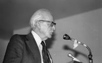 [Photograph of a man speaking at an event]
