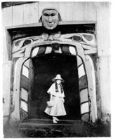 Ne-kar-at-see, portrait of a Kwakiutl woman standing in a doorway
